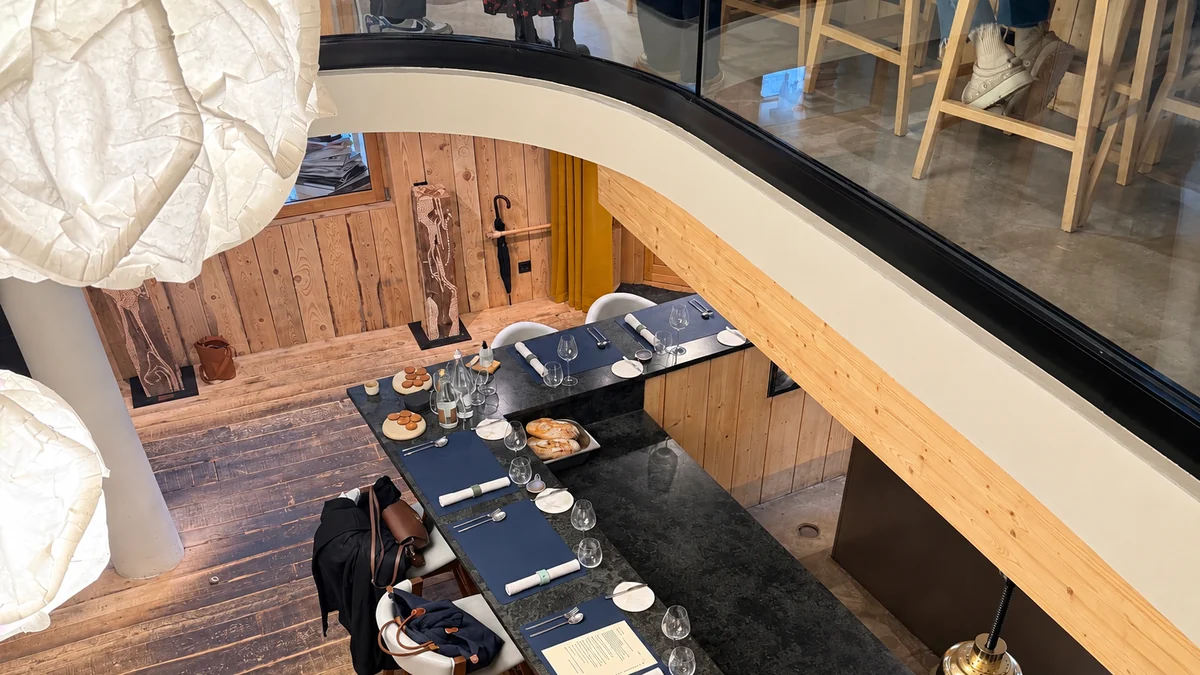 La salle de Vous : long comptoir en pierre sombre et bois clair, sans serveur.